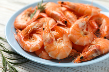 Plate with shrimps on wooden background, close up