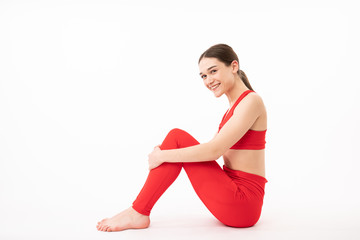 Attractive girl hugging her legs. Photo of young girl sitting on white background. Beauty and body care concept