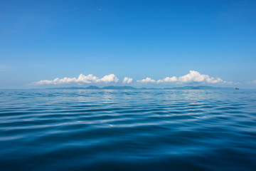 Blue Ocean with waves and clear blue sky Blue water surface. Travel destination and nature environment concept - Ocean water surface texture, summer holiday background