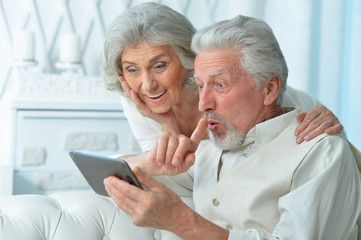 Fototapeta premium Portrait of happy senior couple using tablet