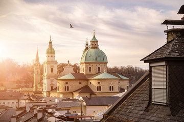 Fototapeta na wymiar Impressive evening scenery over Salzburg: Rooftops of Cathedral, churches and houses