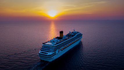 A cruise ship at sea with a sunset