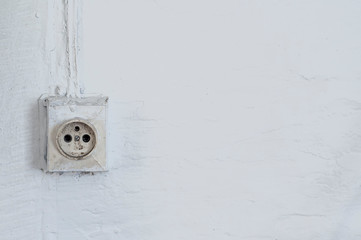 Old dangerous electric plug on a wall