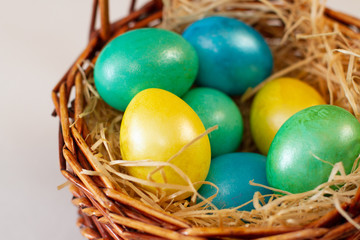 multi-colored easter eggs in a brown basket