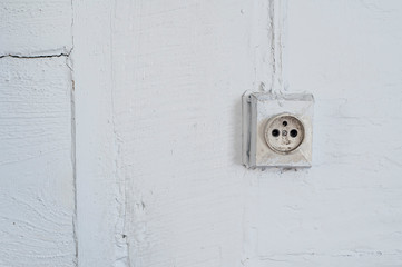 Old dangerous electric plug on a wall