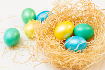 Fototapeta na wymiar set of bright multi-colored easter eggs in a basket of sawdust