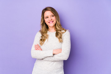 Fototapeta premium Young caucasian woman isolated on purple background smiling confident with crossed arms.
