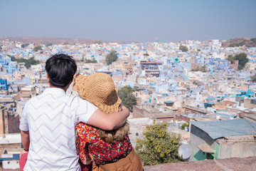 Fototapeta na wymiar Portrait of a couple against view of Jodhpur the blue city in Rajasthan India