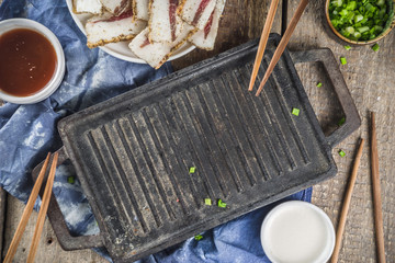 Korean traditional national food. Asian food. Korean food frozen pork belly, Sliced pork belly, Samgyeopsal. Grilled pork lard, with sauces and herbs.