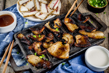 Korean traditional national food. Asian food. Korean food frozen pork belly, Sliced pork belly, Samgyeopsal. Grilled pork lard, with sauces and herbs.