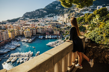 Beautiful young  woman looking at the view of Monaco. Fascinating lady standing at viewpoint and...