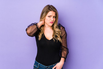 Fototapeta premium Young caucasian woman isolated on purple background having a neck pain due to stress, massaging and touching it with hand.
