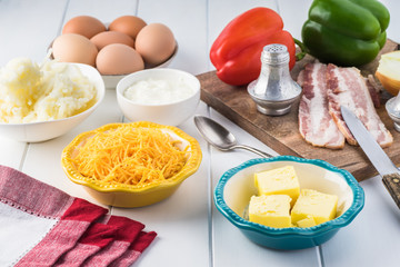 Breakfast casserole with bacon, potatoes, vegetables.