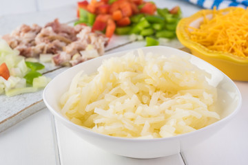 Breakfast casserole with bacon, potatoes, vegetables.