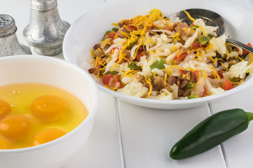 Breakfast casserole with bacon, potatoes, vegetables.