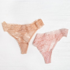 Lace bikini panties light pink colored. Women's lingerie on white background. Top view of...