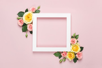 Creative layout made of beautiful roses on pink background. Minimal holiday concept with paper card frame