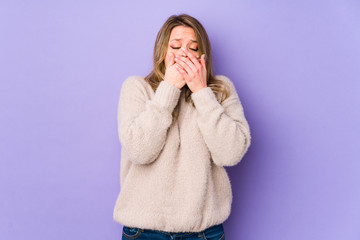 Young caucasian woman isolated on purple background suffers pain in throat due a virus or infection.