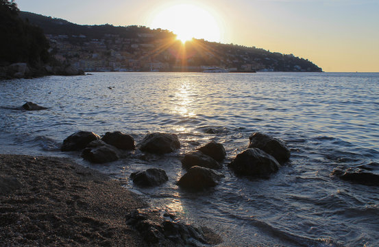 View of Porto Santo Stefano, Tuscany, Italy at sunset from Cantoniera beach with stones on foreground