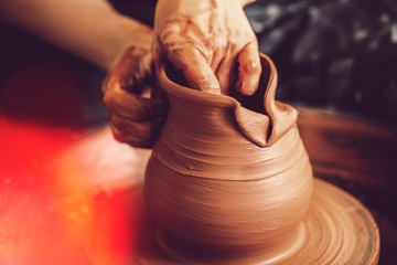 Hands of a potter making clay pot