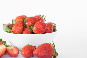 White plate with large ripe fresh strawberries on a white background