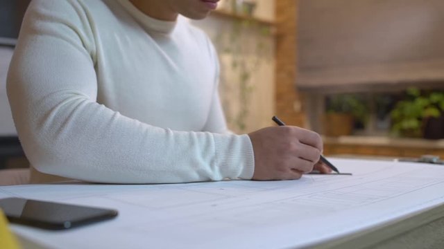 Male architect making technical drawing, draftsman working in office, business