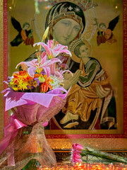 A bouquet of flowers, roses and candles in front of a picture of Mother Mary with Jesus, located at the Binondo church in Manila, Philippines