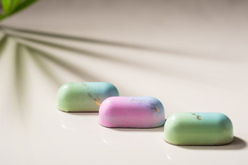 Close up of Chocolate candy and shadows on light surface