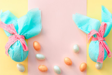 Egg gift in green paper packaging and with pink ribbon Easter Bunny wrap idea. Chocolate dragee...