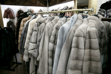 Obraz premium natural fur coats hang on hangers in a store. Sale of winter warm clothes. Turkish shop