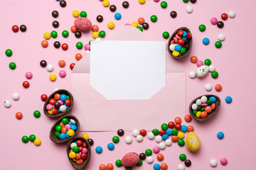 Fototapeta na wymiar Empty template mockup white blank on a pink Easter background. Scattered multi-colored candy. - Copyspace