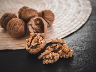 Whole walnuts on dark board. Walnut kernels on dark background. Healthy food nuts.
