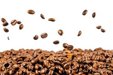 coffee beans fall on a heap of coffee beans