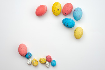 Fototapeta na wymiar Colorful eggs on a white background closeup. Easter background, copyspace