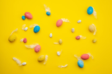 feathers, multi-colored Easter eggs are scattered on the table