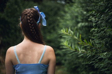 Teenage girl in blue dress in the garden