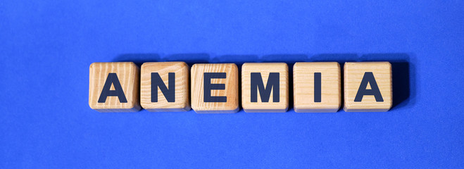 Words anemia on wooden cubes on a blue background
