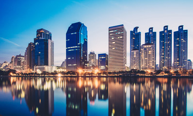 Fototapeta na wymiar Business district cityscape from park,Benchakitti Park in Morning with cityscape reflection, Bangkok Thailand.