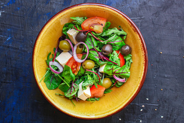 healthy salad olives, lettuce, tomato and cheese feta (greek salad, tasty vegetables snack) menu concept background. top view. copy space