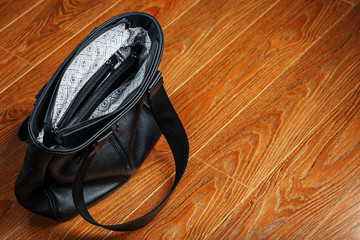 Black leather bag handmade on a wooden background Handmade, natural materials.