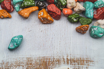 Candy pebbles. sweets in the form of colored stones. wooden background with colorful candies