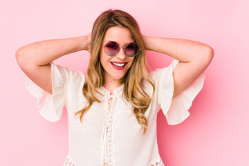 Young caucian woman with glasses isolated on pink background screaming, very excited, passionate, satisfied with something.