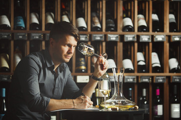 Man looking at wine glass with alcoholic drink