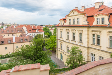 Obraz premium View of the top of old buildings with red roof and dramatic sky at Prague city Czech republic.