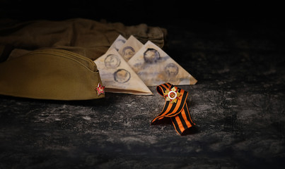 May 9 victory day holiday background. ribbon of St.George, soldier's war letter, old military cap - traditional symbol of Victory Day 1945.