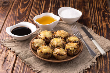 baked mushrooms with vegetables and cheese on a plate.