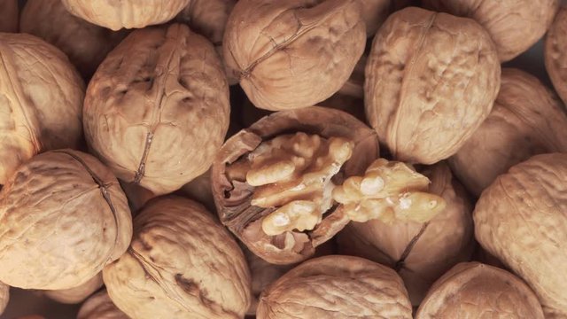 Walnuts group and cracked walnut turning. Top view. Close up. Juglans regia