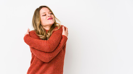 Young caucasian woman isolated on white background hugs, smiling carefree and happy.