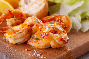 grilled tiger shrimps with spices, sweet and sour sauce, lemon and lettuce