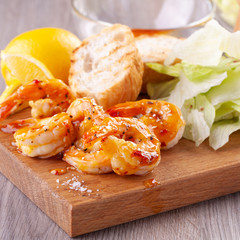 grilled tiger shrimps with spices, sweet and sour sauce, lemon and lettuce